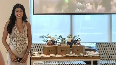 Vanesha Majithia, founder of Luvih, standing beside the luxury fragrance display at the Luvih perfume launch event, showcasing niche international fragrances, premium packaging, and luxury scent experiences in India.